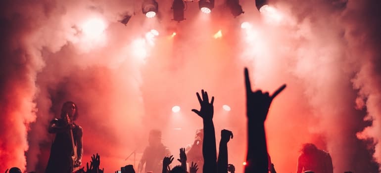People on concert with hands up